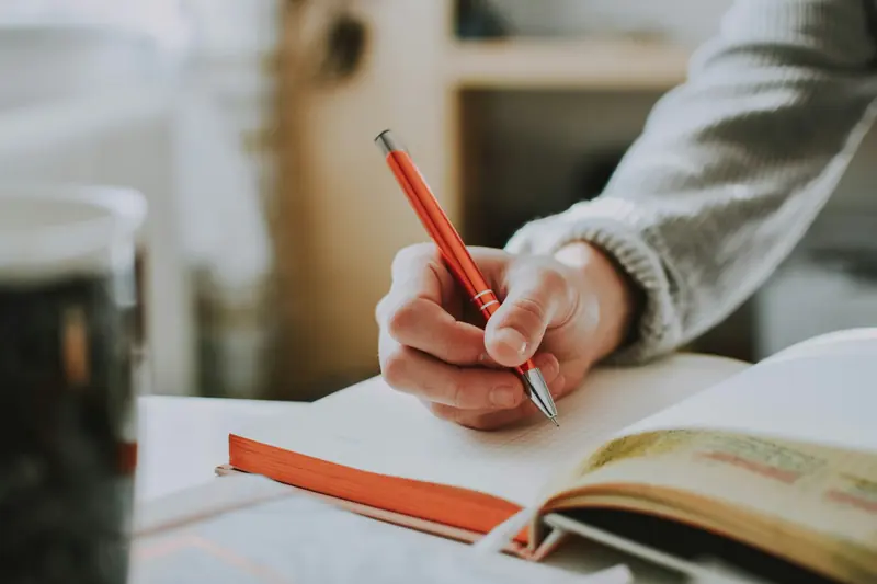 Editor reviewing a manuscript with a red pen