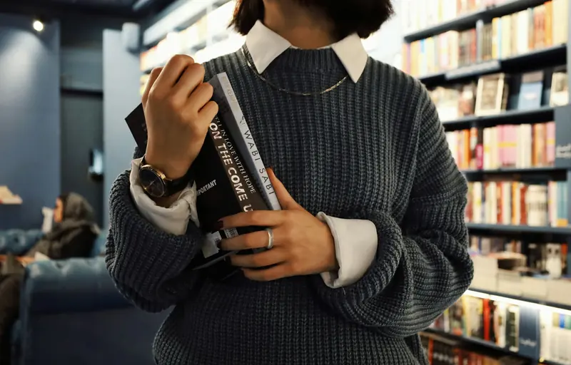 Reader holding a book in a library